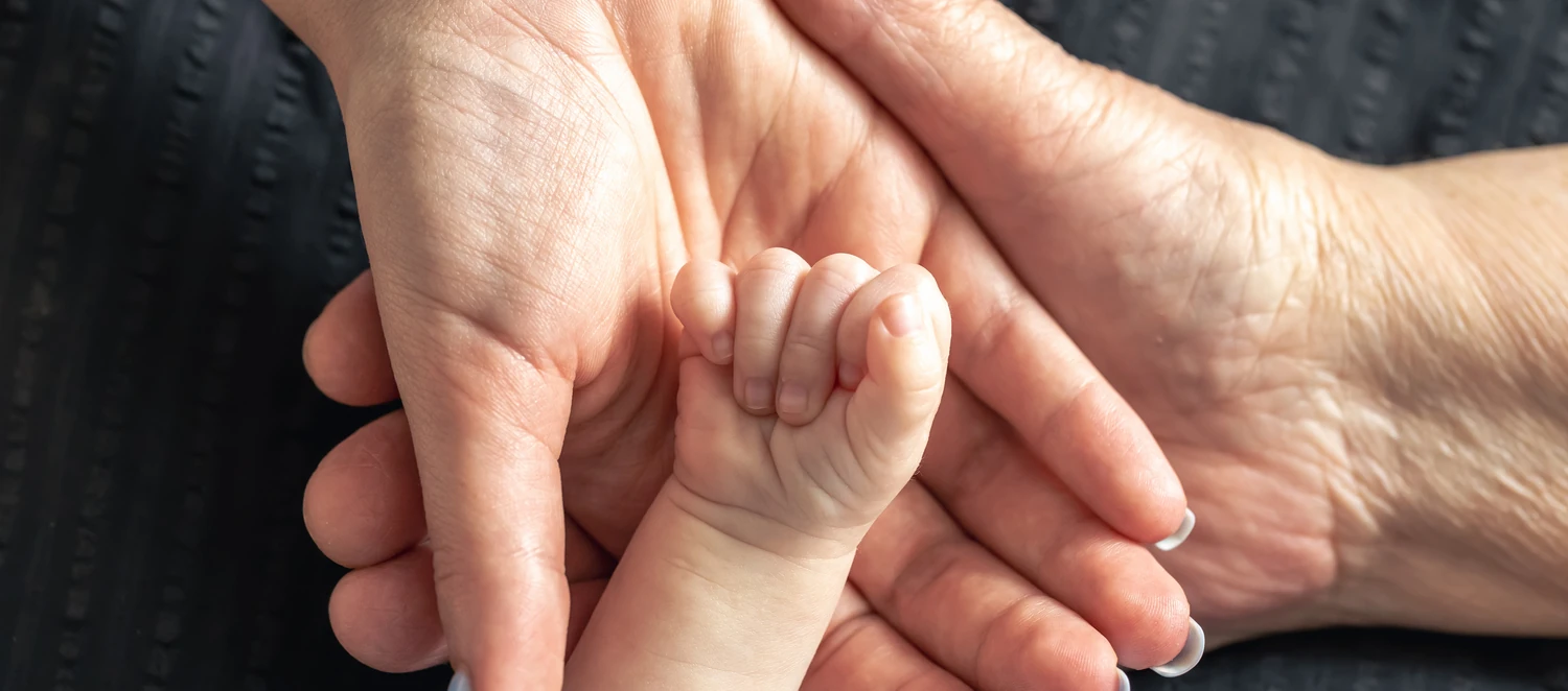 Nahaufnahme der Hände eines Babys, der Mutter und der Großmutter