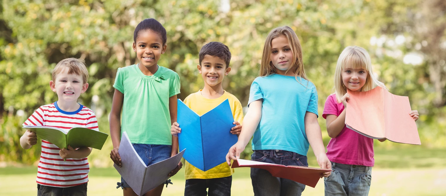 Fünf lächelnde Kinder, die eine Notizmappe halten